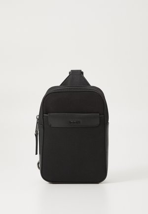 Borsa a tracolla nera in nylon con finitura testurizzata, chiusura con zip, tasca frontale e logo inciso. Dotata di manico superiore per un facile trasporto.