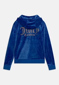 Blå velour hoodie med en stor glittrande "Juicy Couture"-logotyp på baksidan, långa ärmar och en huva. Mjuk textur med ribbade ärmslut.