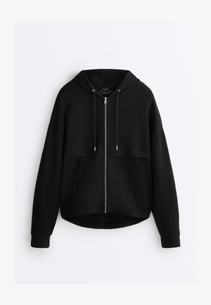 Zwarte hoodie met ritssluiting, trekkoorden, lange mouwen en voorzakken, getoond tegen een witte achtergrond.