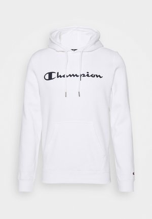 Sudadera con capucha blanca con bolsillo delantero tipo canguro y cordones, con el logo "Champion" en negro en el pecho y un pequeño logo en el puño de la manga izquierda.