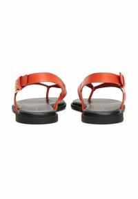 Sandalias rojas de cuero con suela plana negra, que cuentan con una tira ancha y hebilla ajustable para un ajuste seguro. Diseño minimalista.