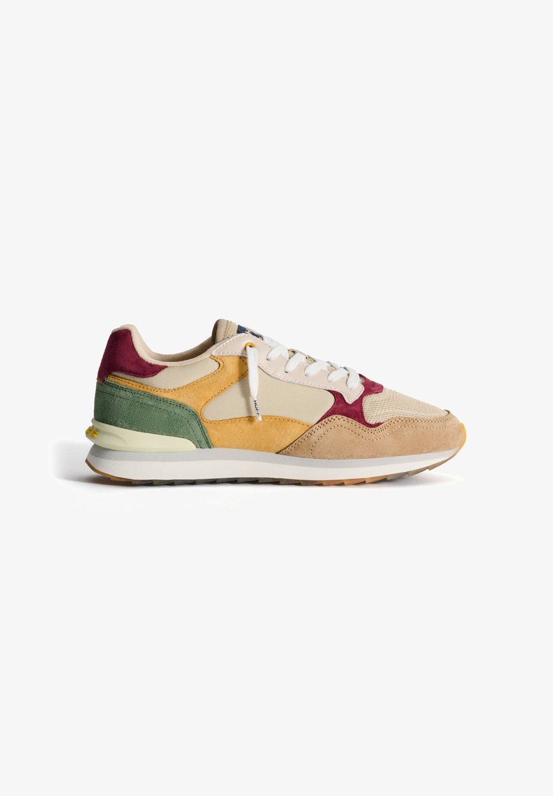 Sneaker realizzato in suede e reticolo, con una base beige e dettagli gialli, bordeaux e verdi, suola texturizzata e lacci bianchi.