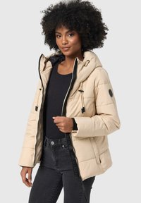 Beige puffer jacket with a hood, black zipper and accents. Features a quilted design and adjustable drawstrings for a secure fit.