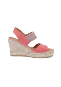 Sandale compensée avec une tige en daim corail, une sangle élastique et une semelle en espadrille tissée. Design à bout ouvert avec des coutures décoratives sur la sangle.