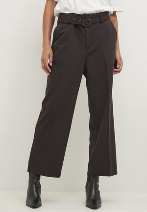 Bruine high-waisted broek met een ceintuur in de taille, wijdvallend ontwerp en een soepele textuur, gecombineerd met zwarte enkellaarsjes.