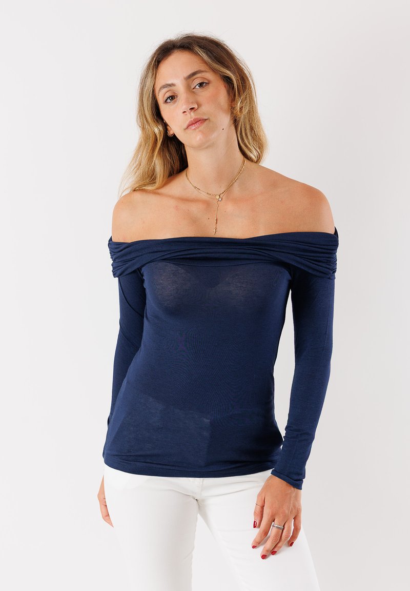 Top blu navy a spalle scoperte con maniche lunghe, realizzato in tessuto leggero, con dettagli drappeggiati attorno al collo.