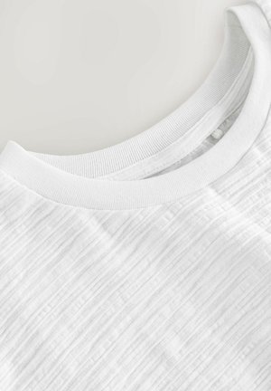 Witte T-shirt met korte mouwen en een ribbelige ronde halslijn, gemaakt van een textuur met een lichtgestreept patroon. Zacht en lichtgewicht materiaal.