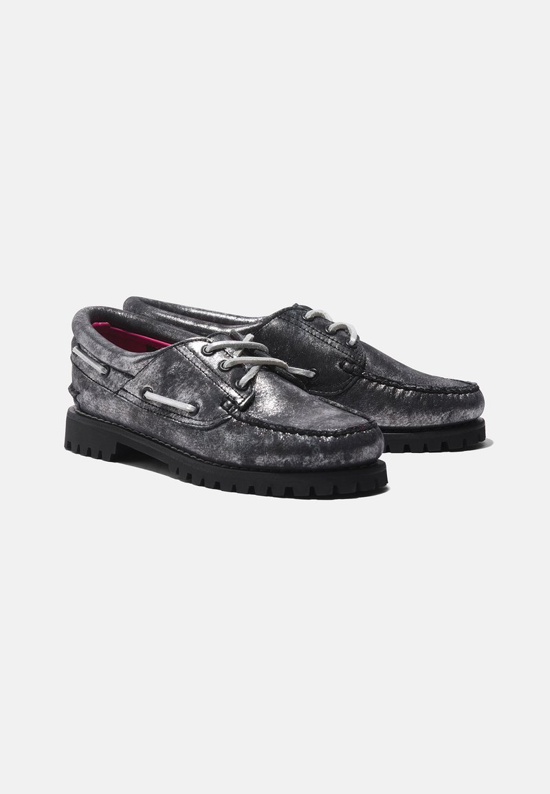 Scarpe da barca nere metallizzate con lacci grigi, tomaia testurizzata e suola spessa in gomma nera con battistrada sagomato per una migliore trazione.
