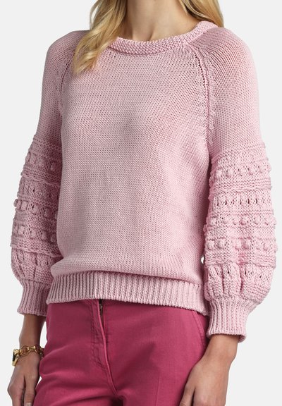 Jersey rosa claro de punto con escote redondo, mangas con textura abullonada y bajo acanalado. Presenta patrones detallados en las mangas.