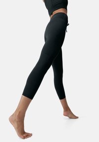 Mustat leggingsit, joissa on tiukka muotoilu, sileä pinta, nilkkapituus ja joustava vyötärönauha, jossa on nauhakiristys.