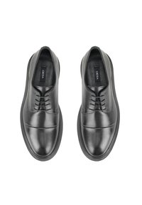 Zwarte leren schoenen met een gladde, glanzende afwerking. Rondneus, vetersluiting en een gewatteerde zool. Logo zichtbaar op de binnenzool.