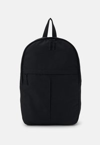 Sac à dos noir en tissu lisse et durable. Caractéristiques : forme arrondie, poignée supérieure et poche zippée à l'avant pour le rangement.