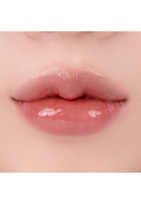 Glänzende, vollere Lippen mit einem sanften Rosaton. Glatte Textur mit einem leichten Schimmer, der ein natürliches, hydratisiertes Erscheinungsbild zeigt.