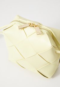 Yellow woven leather pouch with a zipper closure and gold-tone hardware. Features a textured surface with a grid pattern.