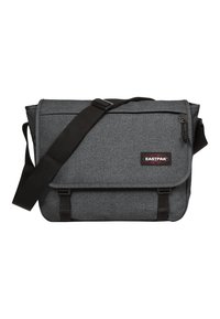 Borsa a tracolla grigia con tessuto testurizzato, tracolla nera e chiusura con fibbia. Presenta un'etichetta con logo e una tasca con zip frontale.