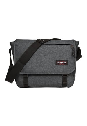 Gray messenger bag with a textured fabric, black strap, and buckle closure. It features a logo patch and a front zip pocket.