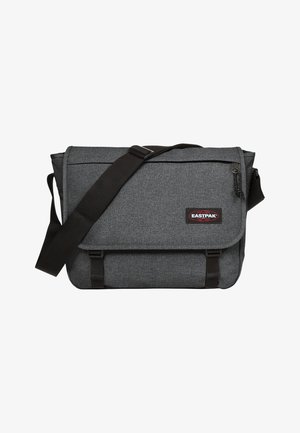 Szara torba na ramię z teksturowanym materiałem, czarnym paskiem i zapięciem na klamrę. Posiada naszywkę z logo oraz przednią kieszeń na zamek.