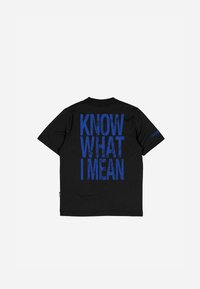 Sort t-shirt med fed blå tekst på ryggen, der står "VED DU HVAD JEG MENER." Enkel design, der understreger budskabet.