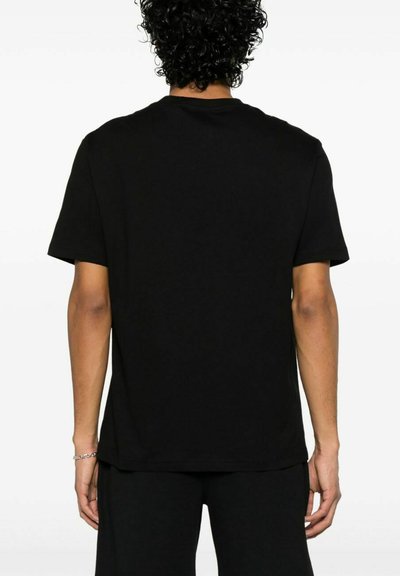 T-shirt in cotone nero con vestibilità rilassata, maniche corte e collo rotondo. Tessuto liscio, design minimale, senza loghi o motivi visibili.