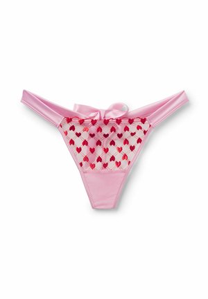 Roze satijnen en mesh string met rode geborduurde hartjes en een kleine satijnen strik aan de tailleband, weergegeven op een witte achtergrond.