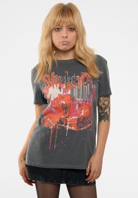 Gray short-sleeve t-shirt featuring a colorful graphic design in orange and pink with distressed accents and bold text.