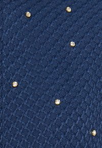 Donkerblauwe gestructureerde stof met een diamantpatroon, versierd met verspreide goudkleurige rhinestones voor extra detail.