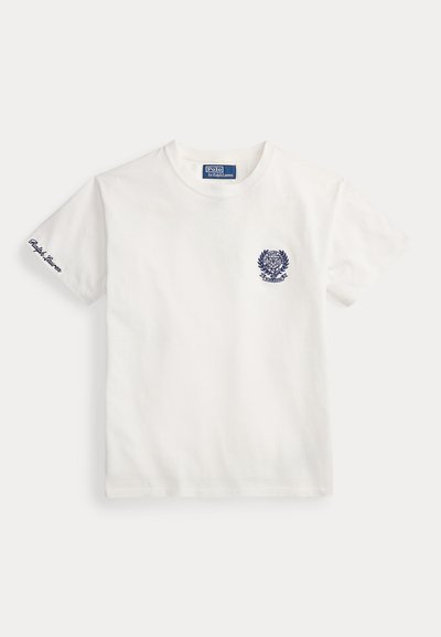 Άσπρο polo με κοντά μανίκια και σκούρο μπλε έμβλημα στο στήθος, με το «"Ralph Lauren"» κεντημένο στο αριστερό μανίκι.