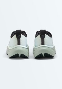 Paire de chaussures de sport gris clair vue de dos, avec des boucles de talon noires et des semelles épaisses et rembourrées portant l'inscription "Freeform".