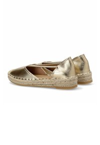 Espadrilles metálicas doradas con suela plana, plantilla de yute trenzado y diseño entrelazado en la parte superior. Textura suave.