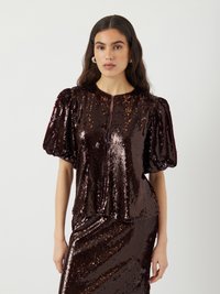 Top a maniche corte in paillettes bordeaux scuro con scollatura rotonda e chiusura con zip, caratterizzato da maniche a palloncino e silhouette aderente.