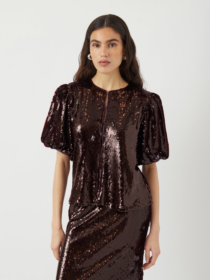 Top a maniche corte in paillettes bordeaux scuro con scollatura rotonda e chiusura con zip, caratterizzato da maniche a palloncino e silhouette aderente.