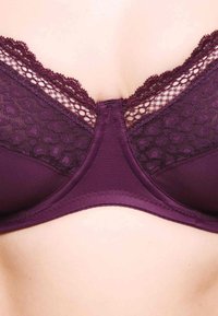 Bordeauxroter BH mit aufwändigen Spitzenverzierungen, glattem Stoff, verstellbaren Trägern und einem dezenten strukturierten Muster entlang der oberen Kante.
