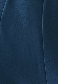 Donkerblauwe stof met een zacht, textuurrijk oppervlak, met subtiele variaties in textuur en een gladde, egale afwerking.