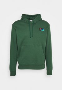 Zielona bluza z kapturem wykonana z mieszanki bawełny, z kieszenią kangurka, regulowanym sznurkiem przy kapturze oraz wyszywaną naszywką z logo w kolorach czerwonym i niebieskim.