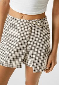 Braun-weißer Hahnentrittmuster-Rock mit einer runden silbernen Schnalle, verfügt über ein Wickeldesign und einen glatten Stoff.