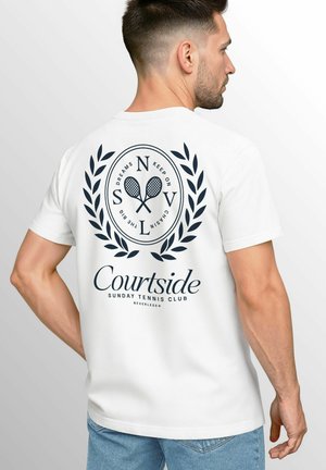 White cotton t-shirt featuring a navy graphic with tennis rackets, laurel design, and text "Courtside Sunday Tennis Club" on the back.