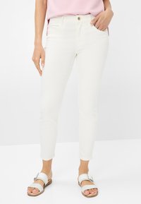 Jean skinny blancs en coton mélangé lisse, avec poches avant et fermeture à un bouton à la taille.