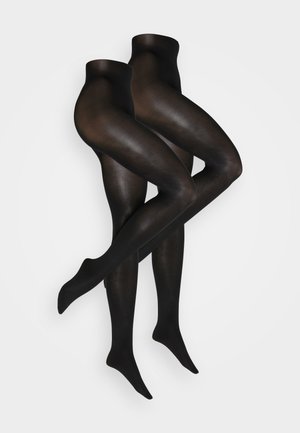 Ein Paar transparente schwarze Strumpfhosen, die mit gekreuzten Beinen auf einem weißen Hintergrund präsentiert werden.