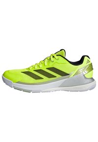 Bright yellow athletic shoe featuring mesh upper, black accents, three diagonal stripes, and a silver heel detail with a white midsole.