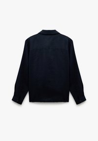 Camisa negra de manga larga con puños abotonados, diseño simple en la parte trasera y un cuello, exhibida de forma plana sobre un fondo blanco.