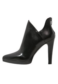 Botín de tobillo de cuero negro con tacón alto, punta afilada, corte en V en la parte superior, suela de plataforma y cierre de cremallera en la parte trasera.