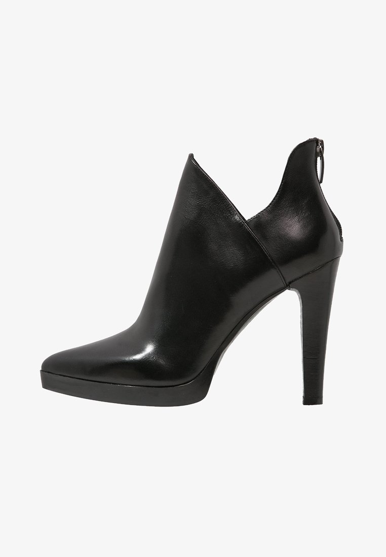 Botín de tobillo de cuero negro con tacón alto, punta afilada, corte en V en la parte superior, suela de plataforma y cierre de cremallera en la parte trasera.