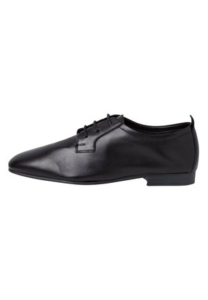 Chaussure de ville pour homme en cuir noir poli avec un bout pointu, fermeture à lacets et petit talon empilé, présentée en vue de côté.