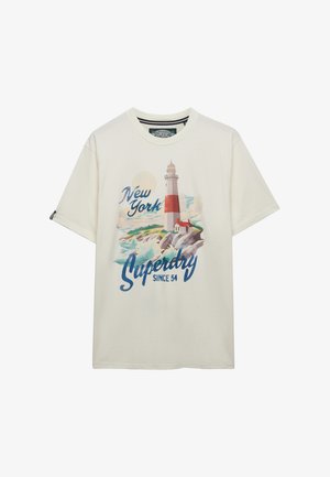 T-shirt crème à manches courtes avec illustration d'un phare et d'une côte rocheuse, et texte « New York Superdry Since 54 » en tons bleus et rouges.