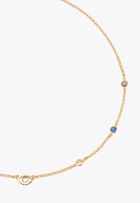 Collier en chaîne dorée comprenant quatre gemmes circulaires : bleu, vert, marron et clair, avec un motif d'œil au centre.