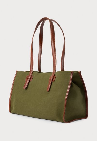 Τσάντα ώμου από καμβά ελιάς με καφέ δερμάτινα χερούλια και φινίρισμα, δομημένο ορθογώνιο σχήμα, λοξή πλευρική όψη σε λευκό φόντο.