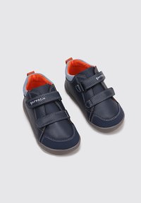 Zapatos de cuero azul marino con dos correas de velcro, detalles en gris y forro naranja brillante, con suela de goma y costuras decorativas.