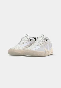 Weiße Sportschuhe mit einem Obermaterial aus Mesh und strukturierten Akzenten, Gummisohlen und kontrastierenden schwarzen Details an der Ferse und den Schnürsenkeln.