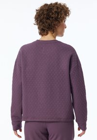 Paarse gewatteerde sweatshirt met een ronde hals en verlaagde schouders, met lange mouwen en een gestructureerd ruitpatroon op de stof.