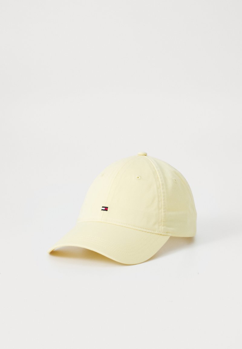 Casquette de baseball en coton jaune avec une visière incurvée et un petit patch de logo avec des bandes rouges, blanches et bleues à l'avant.